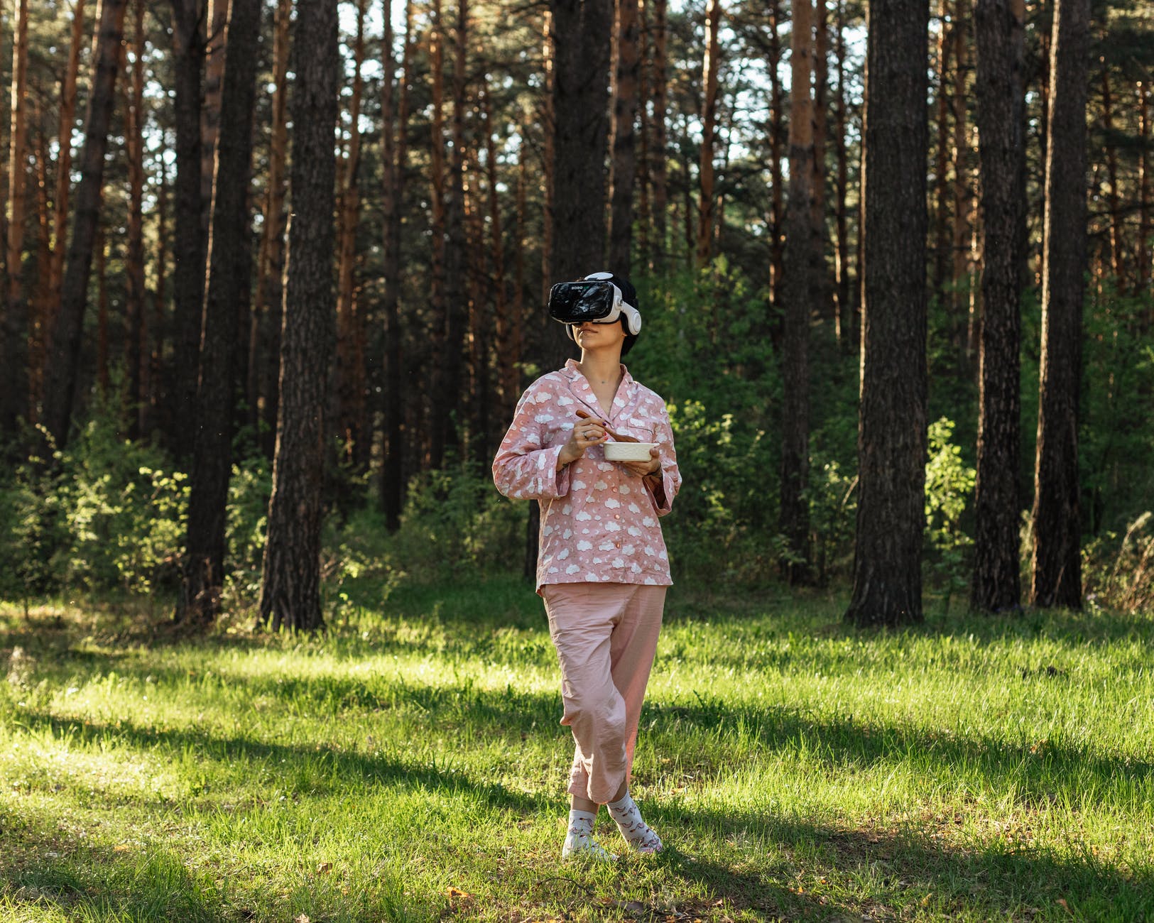anonymous woman with food exploring virtual reality in forest