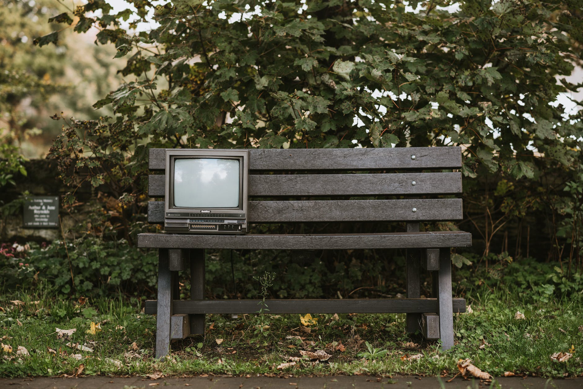 old tv set on bench in nature